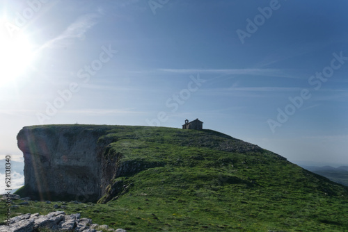 green meadow on the peak of mount beriain, with the hermitage of san donato on the summit. Sierra de Andia, Navarre, Spain