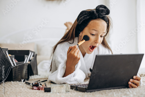 Cute girl adoing makeup with brushes