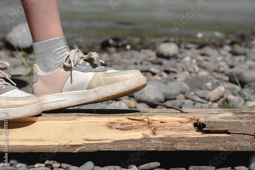 Dangerous situation for a child to prick a foot in sneakers and injure it on a sharp metal nail. Safety children from dangers. Stop risk for child