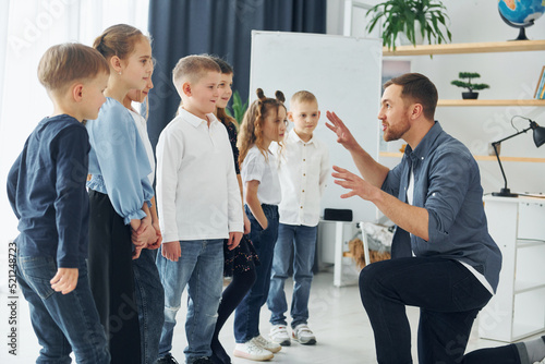 Storyteller with interesting information. Group of children students in class at school with teacher