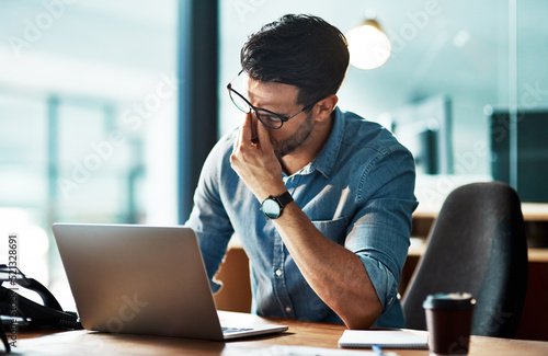 Stressed, tired and frustrated business man with headache at night from burnout or making mistake on laptop. Overworked creative entrepreneur failing to meet late office deadline or working overtime