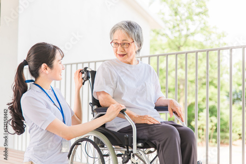 散歩する介護士・理学療法士と高齢者女性（日本人） 