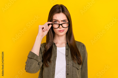 Photo of clever serious businesswoman look at you with judging expression isolated on yellow color background