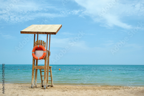 Emplty wooden lifeguard station on sandy beach on ocean shore in summer