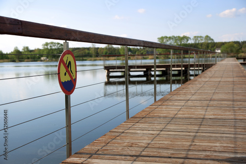 Znak zakazu kąpieli na molo, deptaku na kąpielisku wodnym w Siołkowicach Nowych.