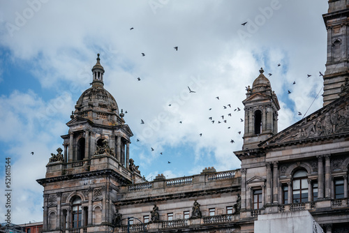 The Victorian and Beaux arts style City Chambers of Glasgow with birds flying in the sky over it