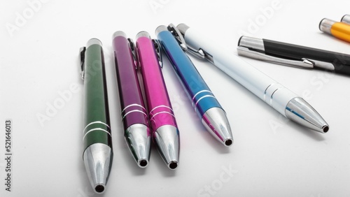 Closeup shot of a row of different-colored pens on a white table