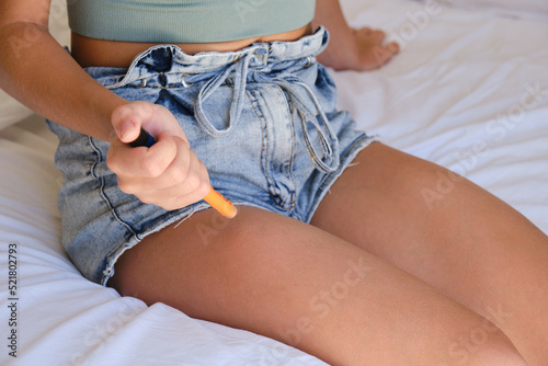 Little girl using insulin pen for making an insulin injection at home.