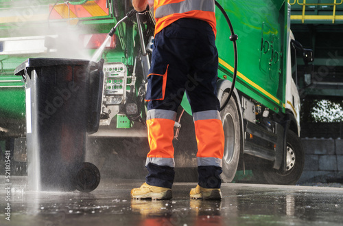 Garbage Truck Operator Pressure Washing Black Trash Can