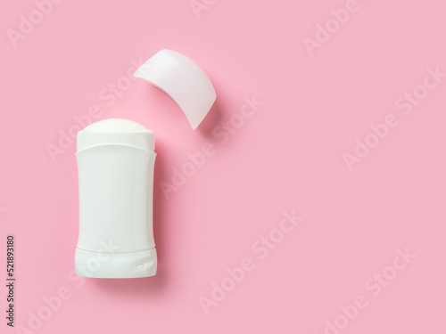 Solid antiperspirant over pink background with copy space. Open white plastic tube of body deodorant close-up. Toiletries for reduce perspiration, hygiene and body care concepts.