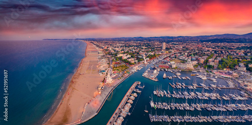 Panoramic summer view from flying drone of Libera Rimini public beach. Incredible evening scene of Italy, Europe. Spectacular sunset on Adriatic coast. Vacation concept background.