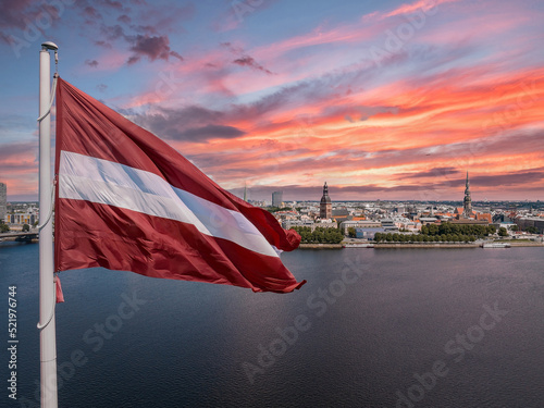 Latvian flag with the Dome Cathedral and an old town in the background in Riga, Latvia, the Baltic countries