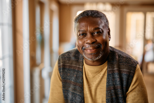 Happy African American senior at nursing home looking at camera.