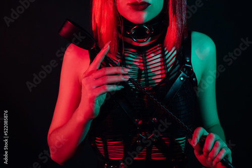 woman with a sexy body in beautiful underwear holds a leather flogger whip in her hand for BDSM sex with domination and submission