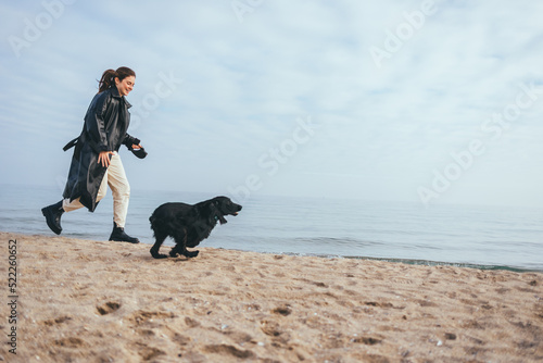 Young woman and her dog black cocker spaniel running
