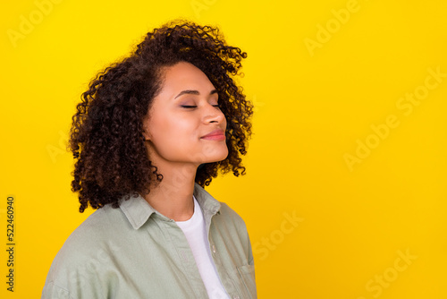 Profile photo of cute curly millennial brunette lady smell promo wear grey shirt isolated on yellow color background