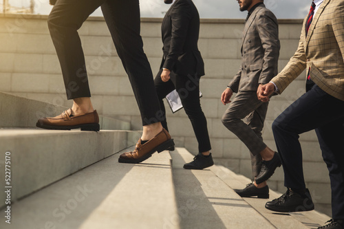 Business people climb the stairs of the city stairs. Close-up of the impersonal legs rising up. Career growth and advancement. Increasing and improving skills. Salary increase