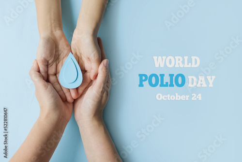 World Polio day. October 24. Blue drop in hands of an adult and child is symbol of polio vaccine. Poliomyelitis is disabling and life-threatening disease caused by poliovirus