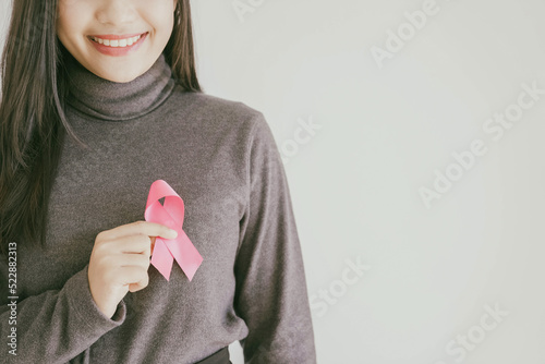 Young Asian woman with pink ribbons, breast cancer awareness, October pink concept, world cancer day