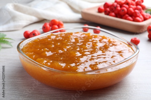 Delicious rowan jam in bowl on white wooden table, closeup