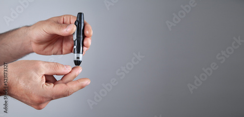 Man using lancet on finger. Checking blood sugar level