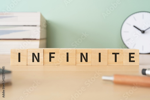 無数・無限・空間のイメージ｜「INFINITE」と書かれたブロックが置かれたデスク 