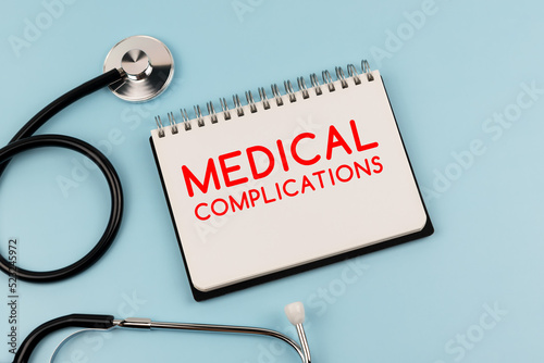 Medical complications text on note pad and stethoscope