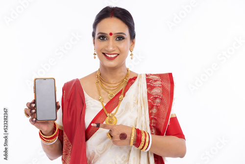 Happy bengali woman in traditional sari showing mobile phone screen 