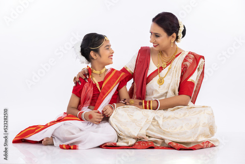 Happy bengali mother and daughter spending leisure time together in traditional clothing 