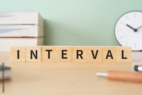 インターバル・間隔のイメージ｜「INTERVAL」と書かれたブロックが置かれたデスク 