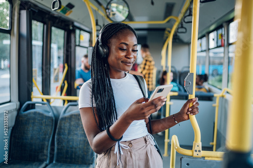 African american woman using smartphone while riding a bus