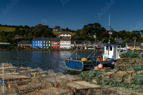 old wooden fishing boat and fishing nets and crab traps in Bantry Bay withe downtown Bantry in the background