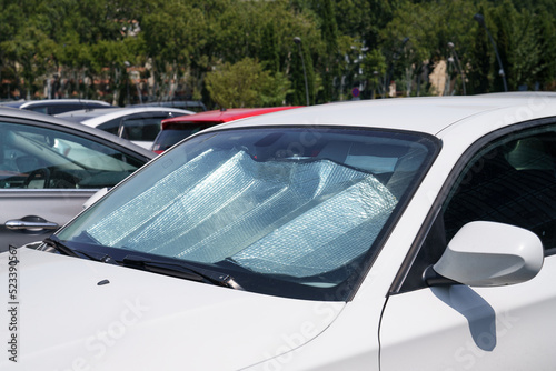 Closeup of protective reflective surface under the windshield of the passenger car parked on a hot day, heated by the sun's rays inside car. Sunshade, Heat protection, auto accessory concept