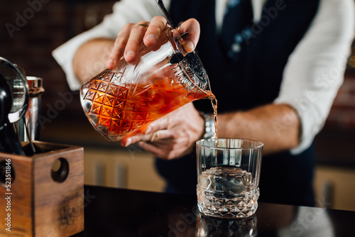 close up of barman pouring drink in glass