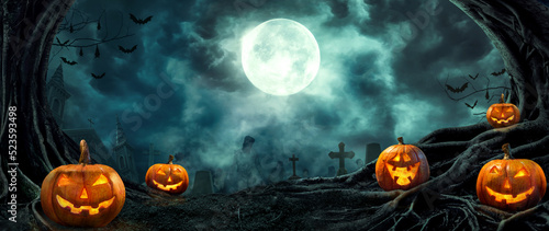 Pumpkin zombie Rising Out Of A Graveyard cemetery and church In Spooky scary dark Night full moon bats on tree. Holiday event halloween banner background concept.