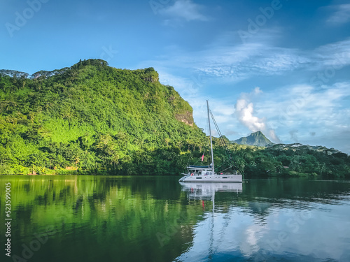 White yacht anchored near mountain coast bay. Sailing boat stop at tropical Island blue sea lagoon. Travel, summer cruise, recreation, leisure activity. French Polynesia Bora Bora exotic luxury tour.