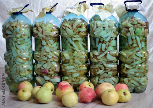 Jabłka pokrojone w plastikowych butelkach. Ocet jabłkowy