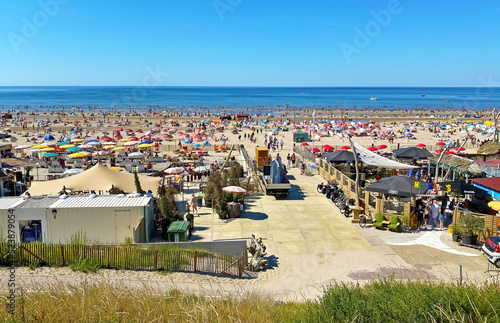 Zandvoort, Netherlands - August 12. 2022: View from dunes on crowded dutch north sea city beach on sunny summer weekend