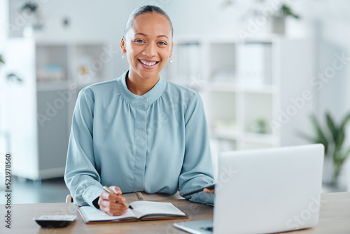 Modern, smiling and young business woman enjoying her work in a office at a computer indoors. Portrait of a happy junior corporate lawyer working, making notes and planning a successful job strategy