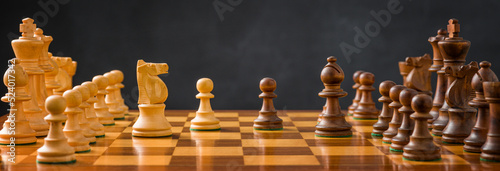 Chess pieces on a chessboard with a dark background