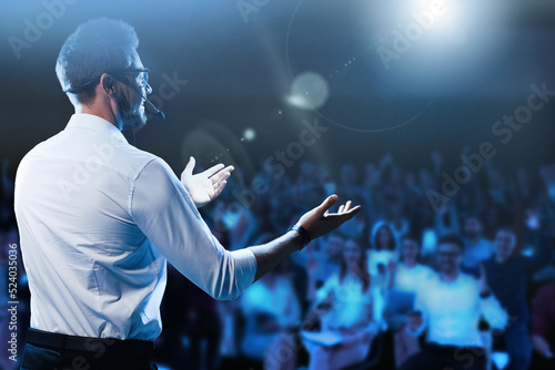 Motivational speaker with headset performing on stage