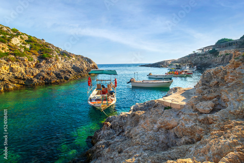 Cozy rocky Porto Roxa beach with boats in the bay, beautiful colored Ionian sea in west Zakynthos, Zakynthos island