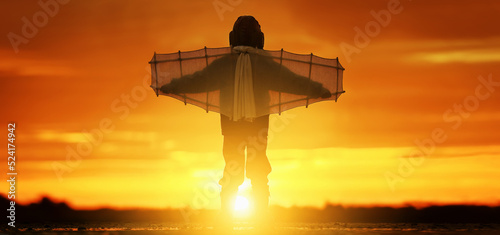 Little boy with wings at sunset imagines himself a pilot and dreams of flying.