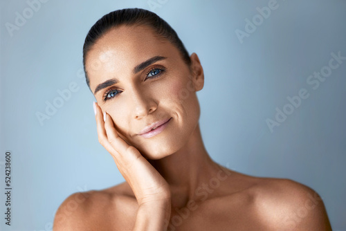 Anti age skin care. Beautiful mature woman touching her face, portrait against grey background