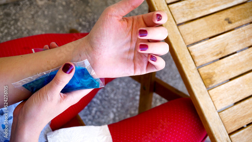 Woman applies cold compress to the ankle