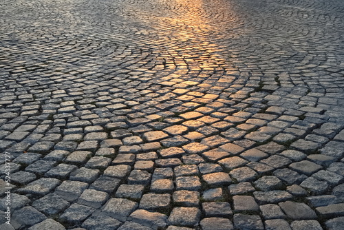 A street in the old town made of granite cubes illuminated by the setting sun
