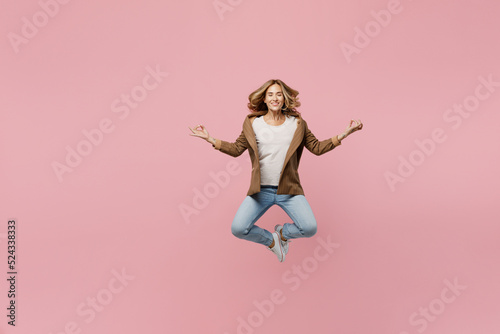 Full body young employee business woman 30s she wear casual brown classic jacket hold spread hand in yoga om aum gesture relax meditate try to calm down isolated on plain pastel light pink background