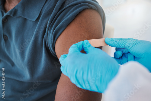 Corona, compliance and the vaccine being given to man by a health care worker. Closeup of a nurse putting a plaster on a man after an injection or treatment. Male making decision to get booster shot
