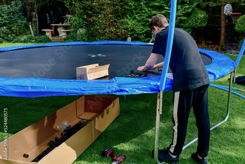 Children collect a disassembled trampoline in the yard after purchase.