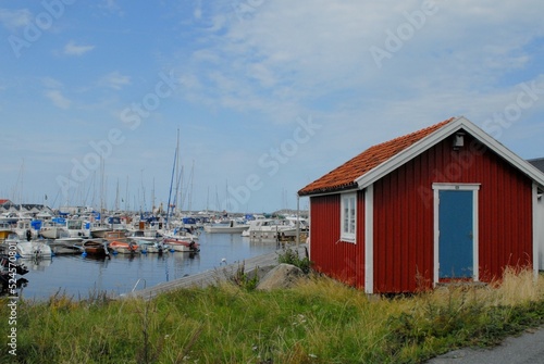 swedish red house with a coast with yachts